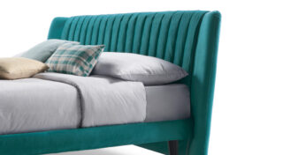 Letto imbottito rivestito in tessuto verde.